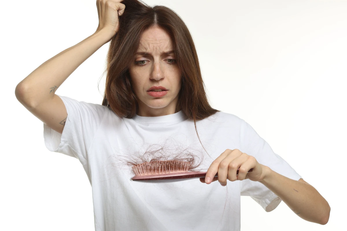 mujer con cepillo lleno de pelo